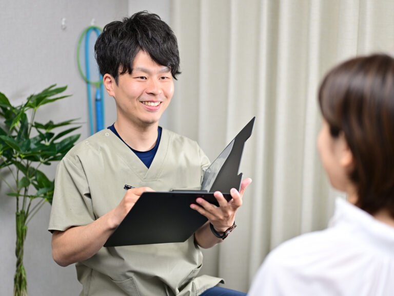 理学療法士の院長が患者様の話を聞きながら検査・カウンセリングを行う様子｜関目高殿の整体院 友