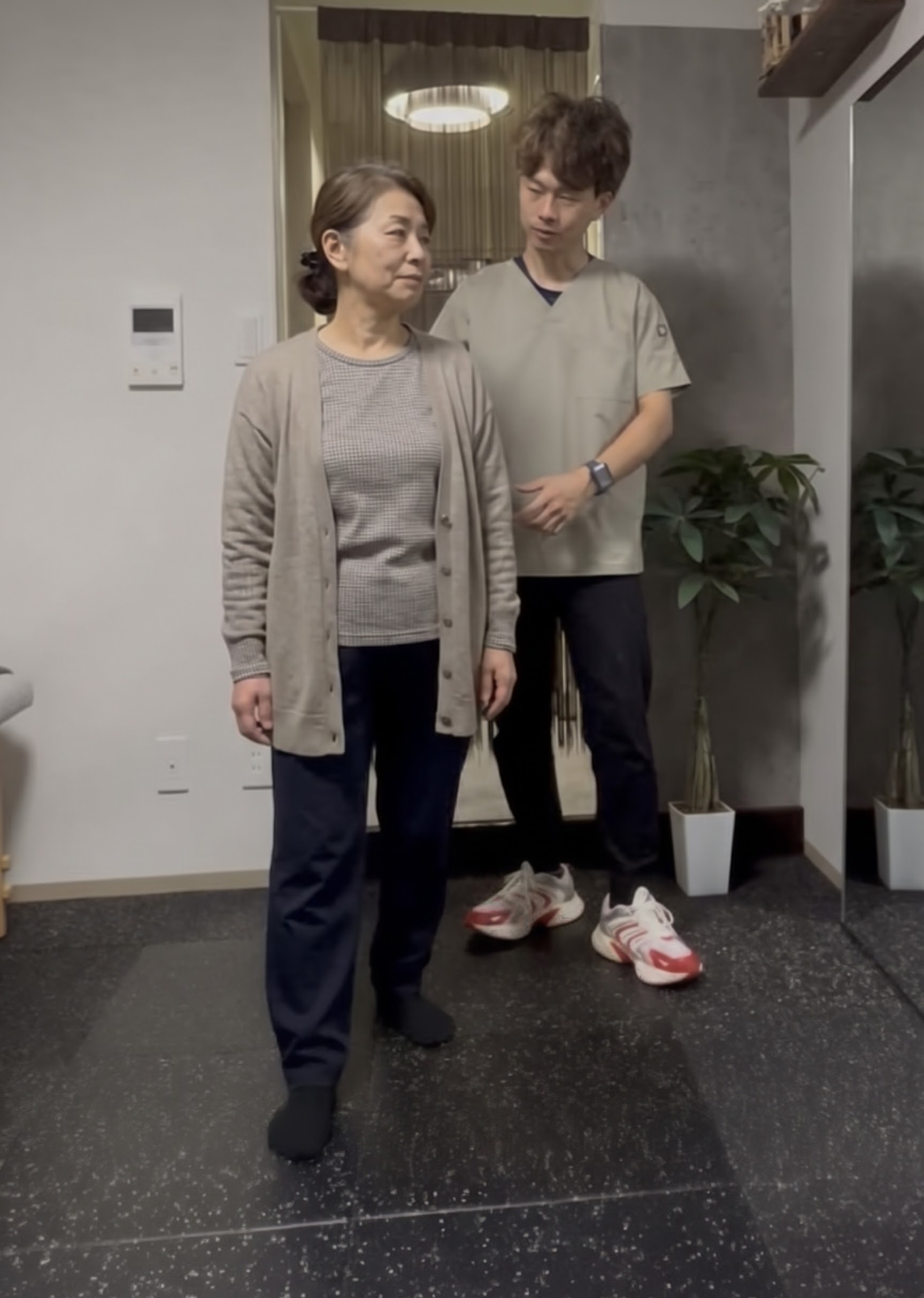 院長が年配の患者さんの立ち姿勢を後ろから確認している様子